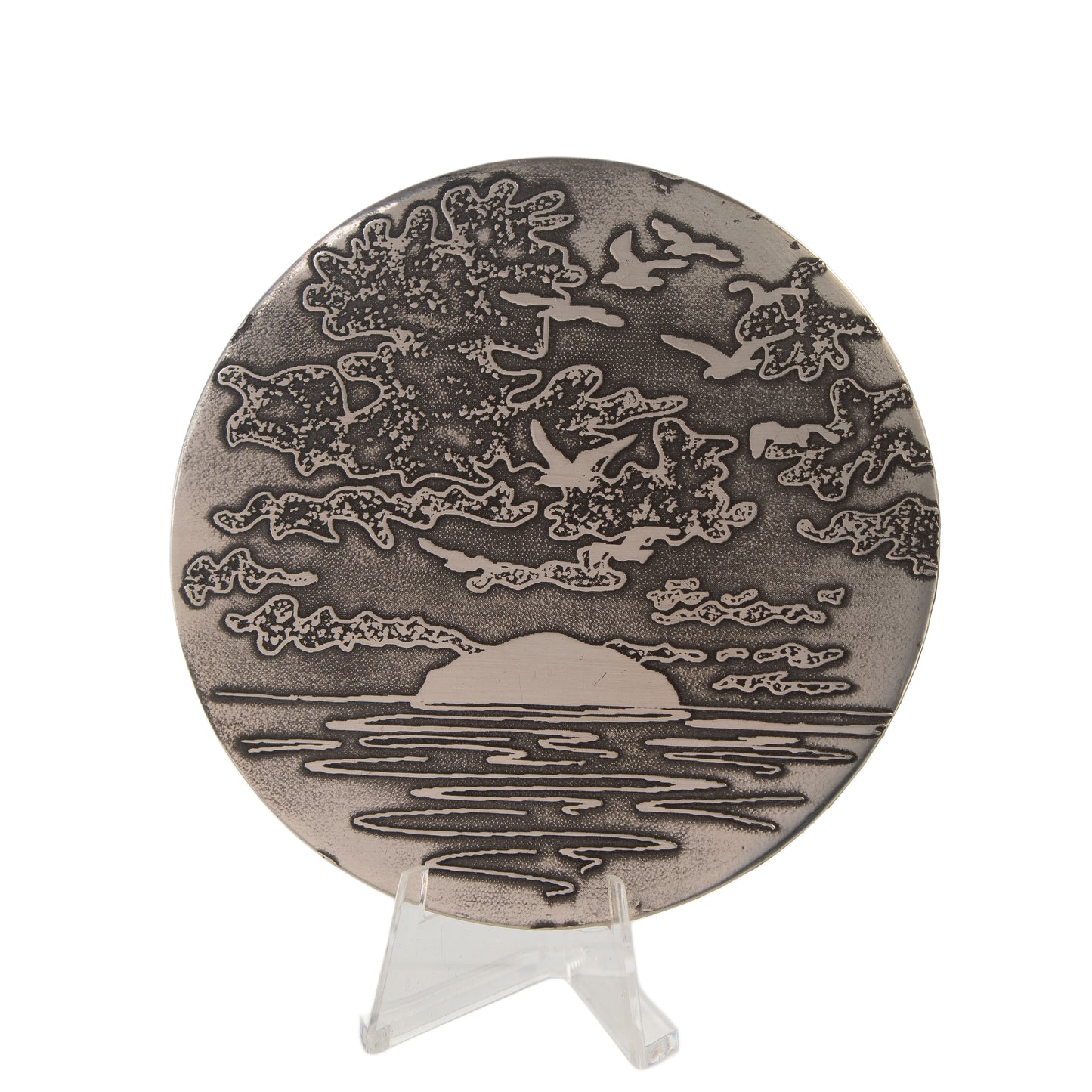 Decorative coaster with ailsa craig and cloud design on a stand against a white background