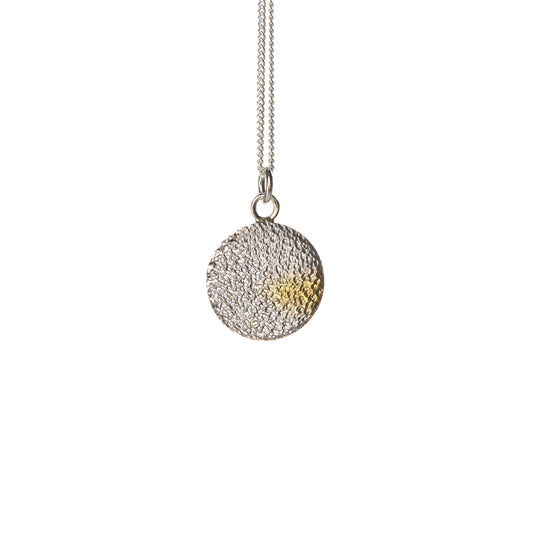 Handmade silver disc pendant with textured finish and gold detail by Bianca O’Neill Jewellery.