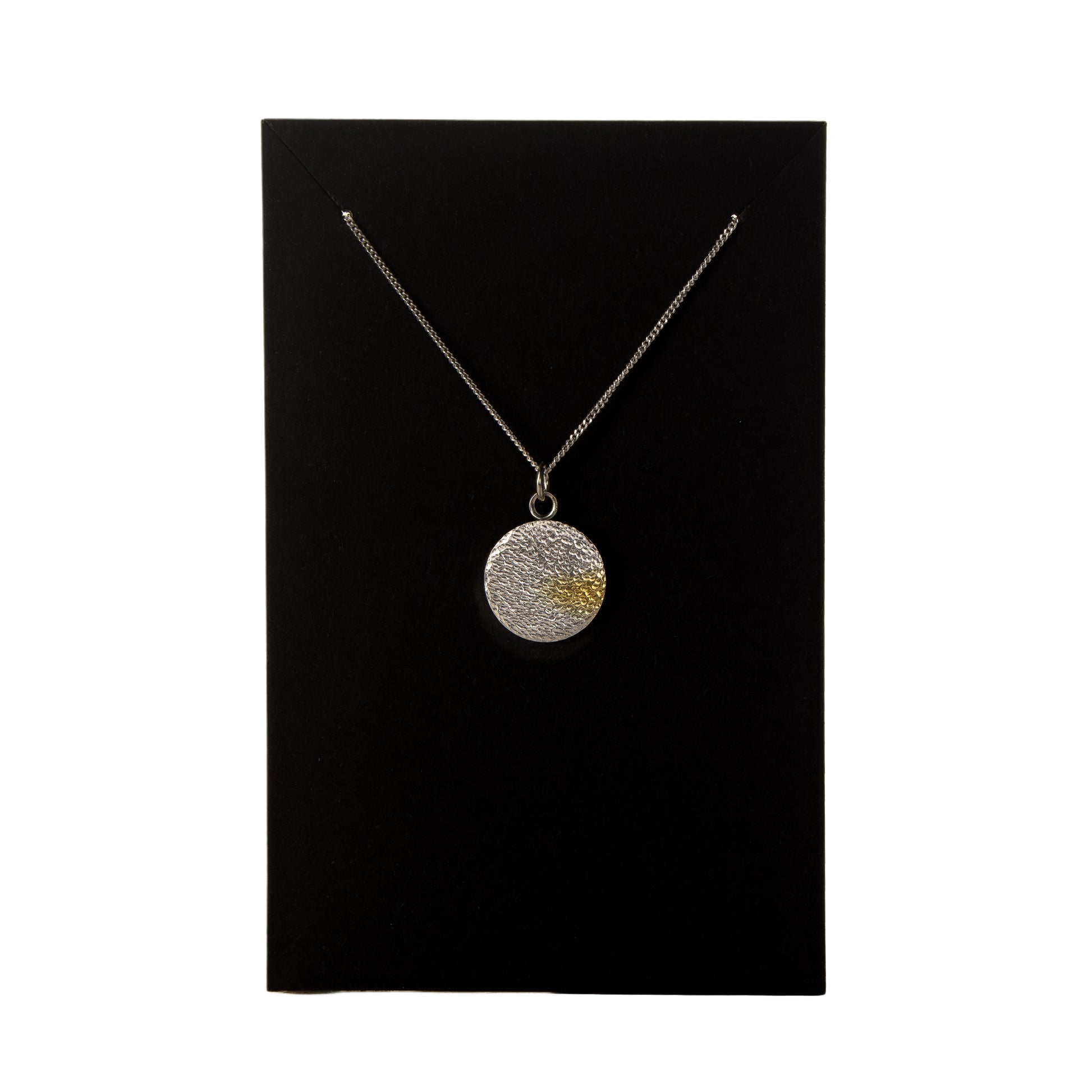 Necklace with a round pendant on a black card