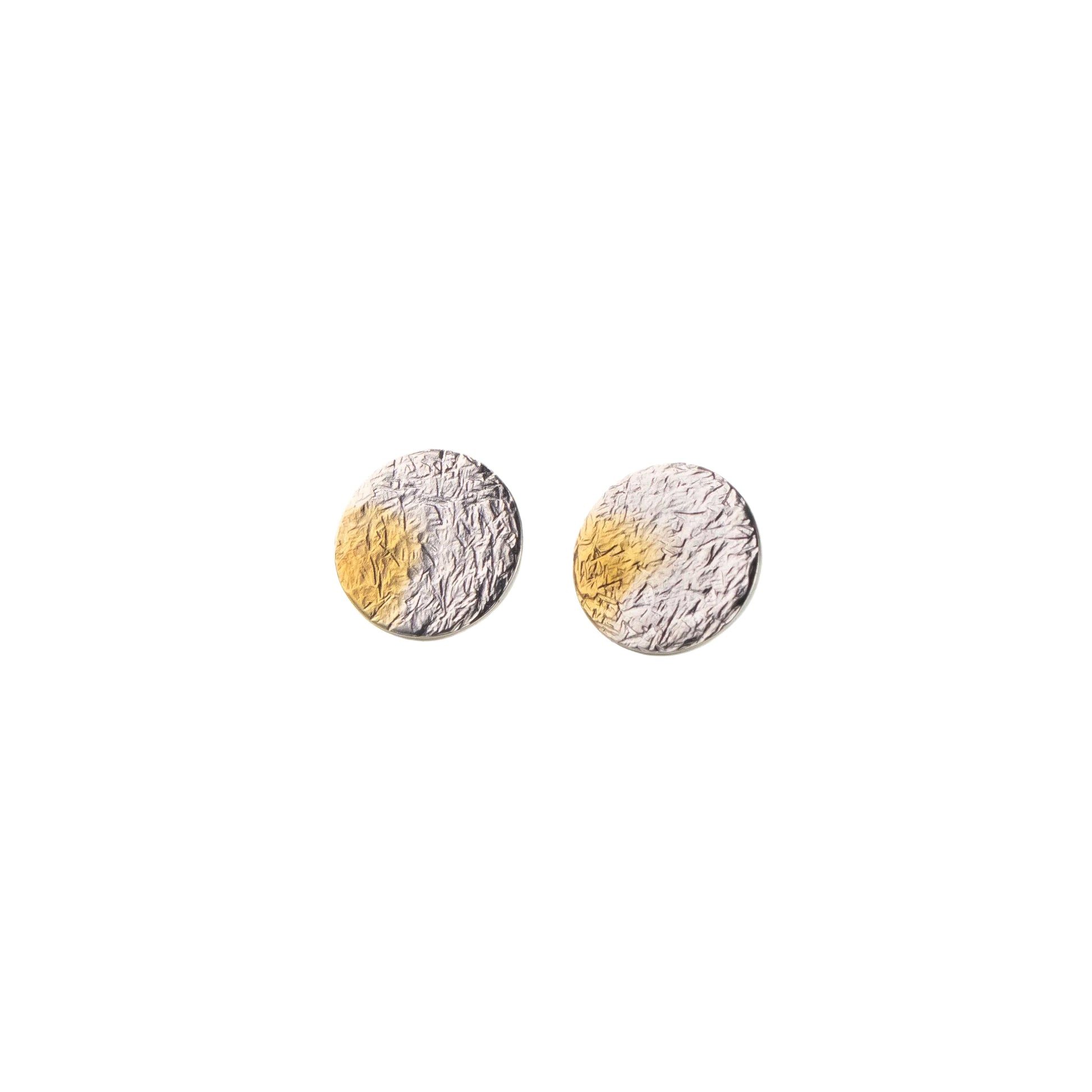 Pair of round earrings with gold and silver finishes on a white background