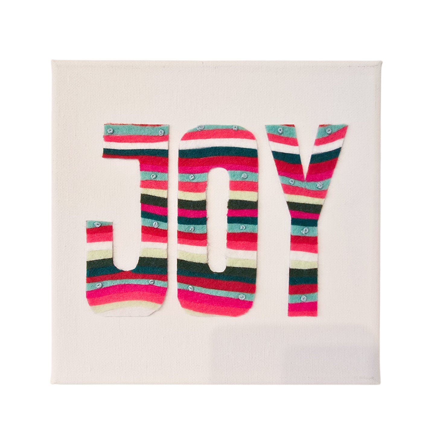 Colourful striped felt “JOY” artwork on white canvas by Gillian Heart Felt.
