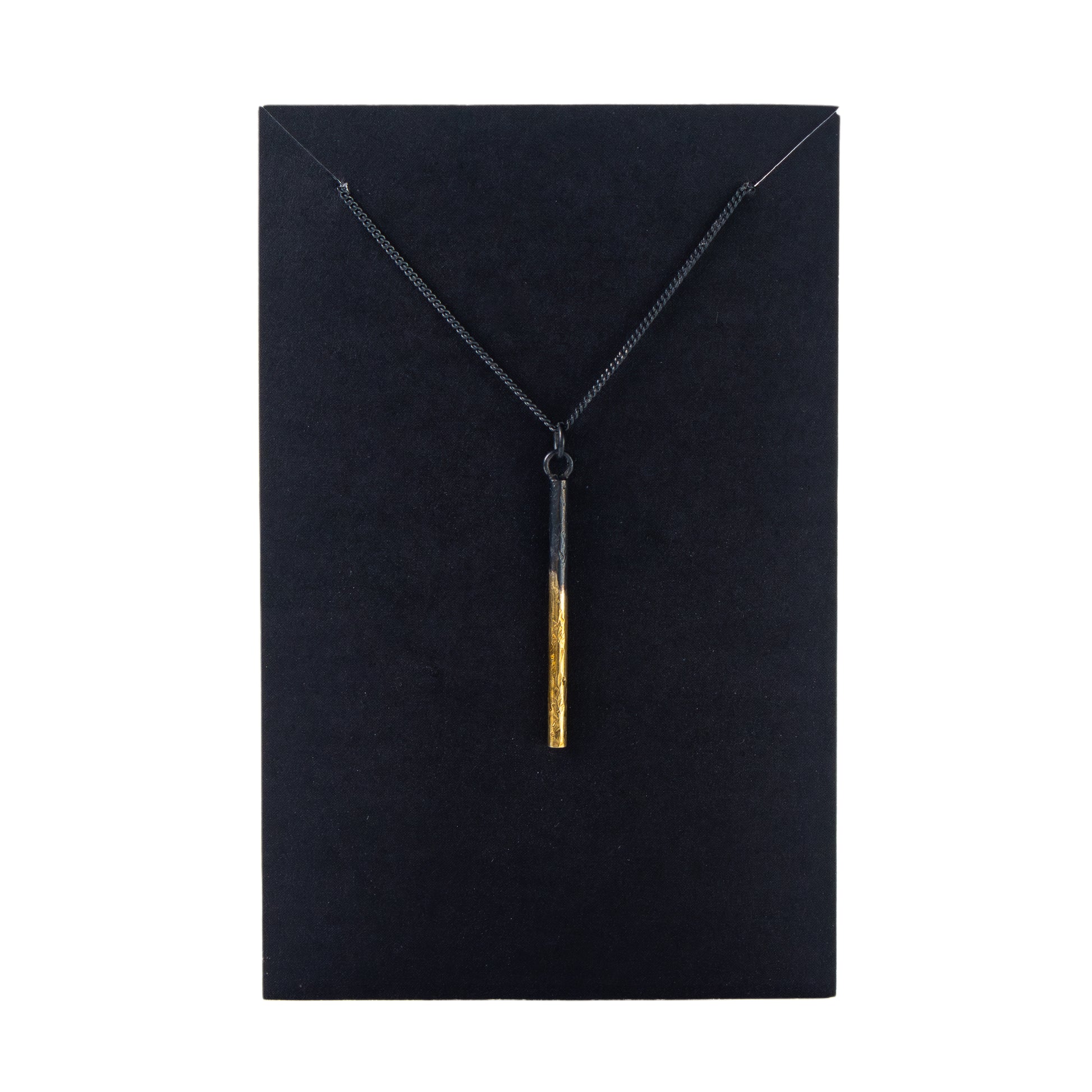Necklace with a gold pendant on a black card
