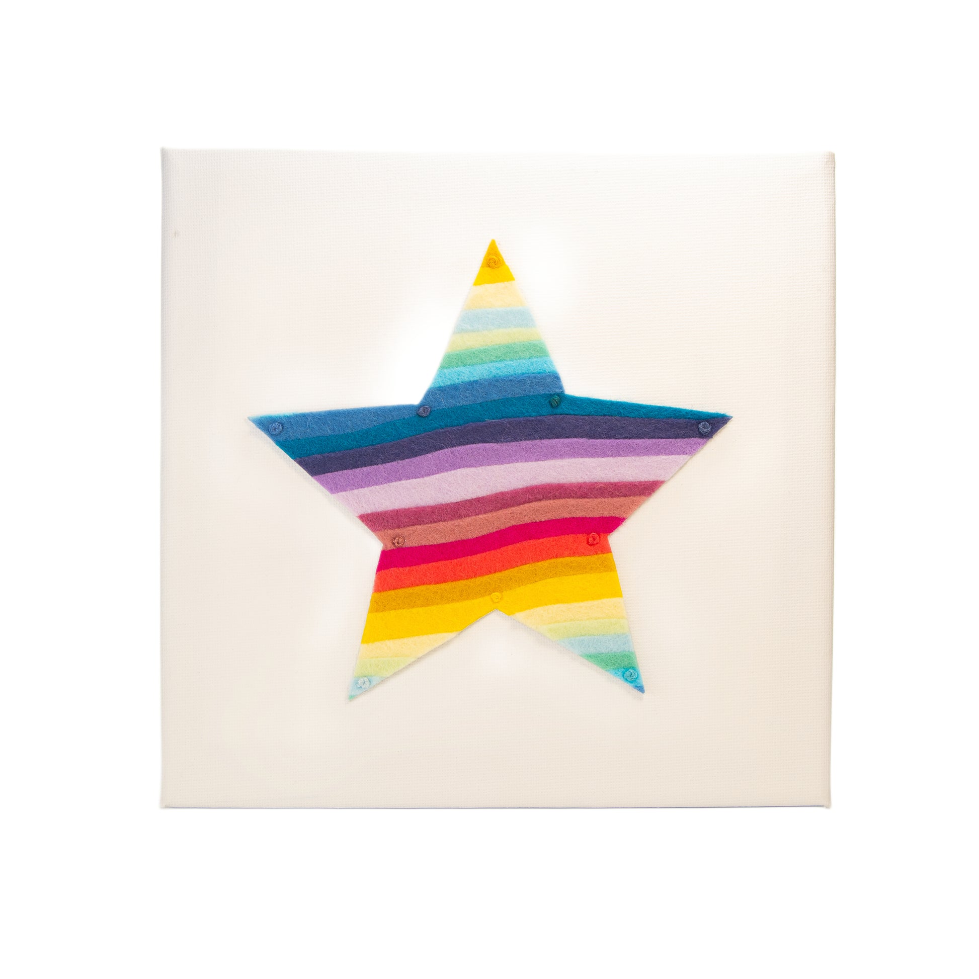 Rainbow layered felt star artwork on white canvas by Gillian Heart Felt.