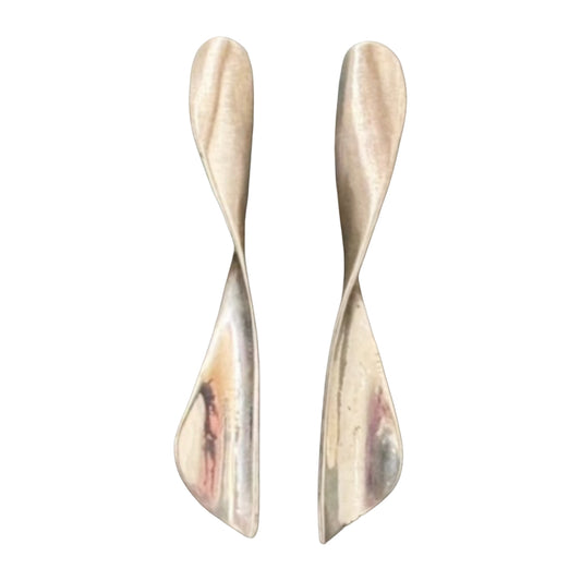 Pair of silver earrings on a textured surface